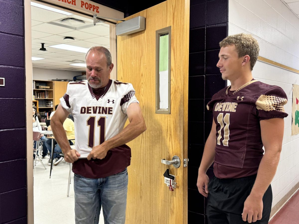 Football Coach and History Teacher Heath Poppe wears varsity quarterback Karter Brown's jersey during the traditional HOCO festivities.