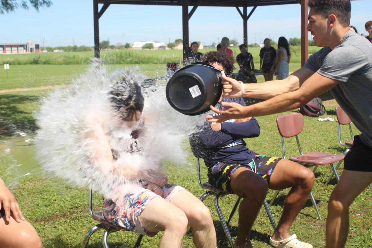 Cole Reyes throws a bucket of water at Cecilio De La Garza.